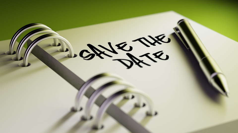 En bild på en kalender eller anteckningsbok med en penna och texten "Save the date".