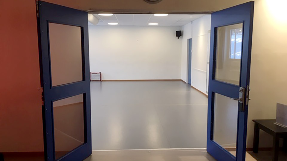 Två
stora blå dörrar som leder in till aktivitetsrummet.