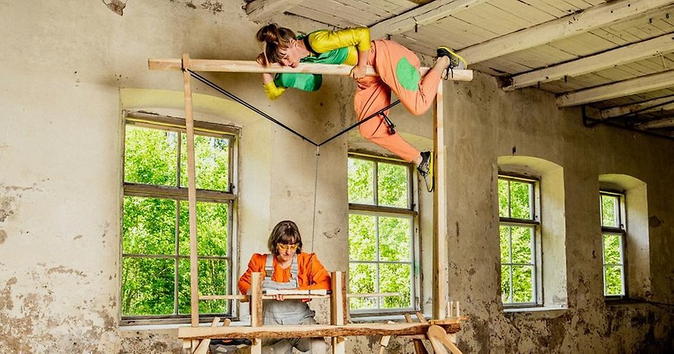 två färgglada figurer som kikar ner i en låda